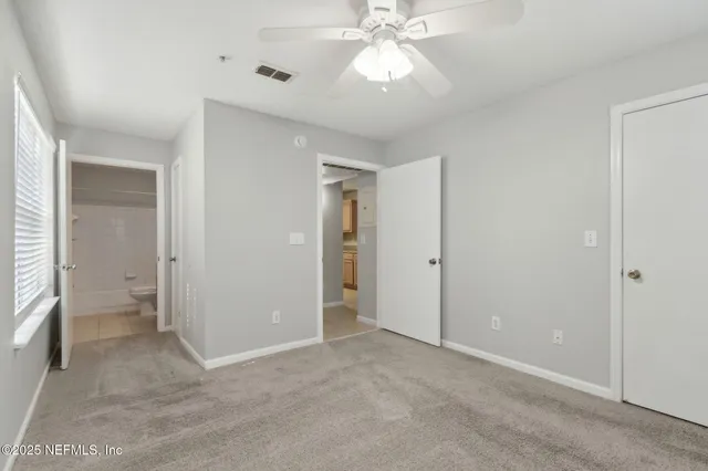 an empty room with a ceiling fan and a fan