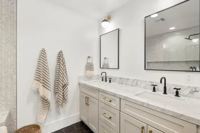 a bathroom with a granite countertop sink mirror vanity and toilet