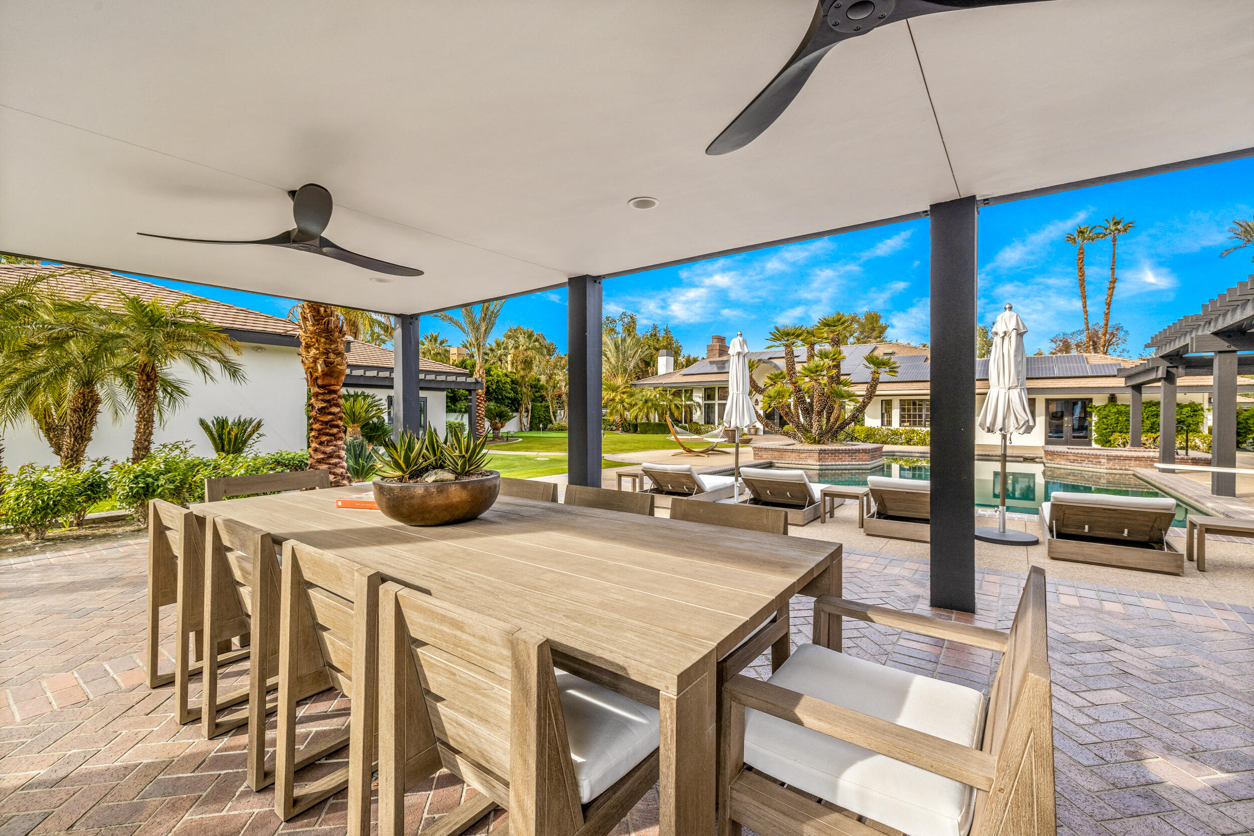 72420 Silver Spur Lane Rancho Mirage, CA 92270 - Photo 75 of 86 a view of a dining room with furniture large windows and wooden floor
