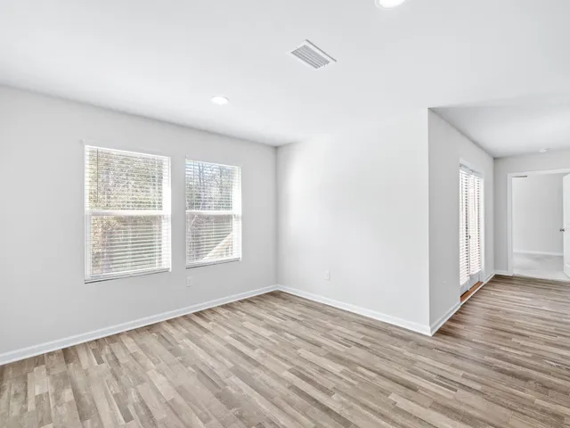 a view of a dining room with furniture a chandelier and wooden floor