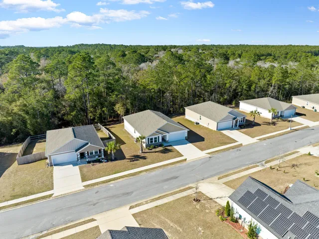 a view of a white house with a yard