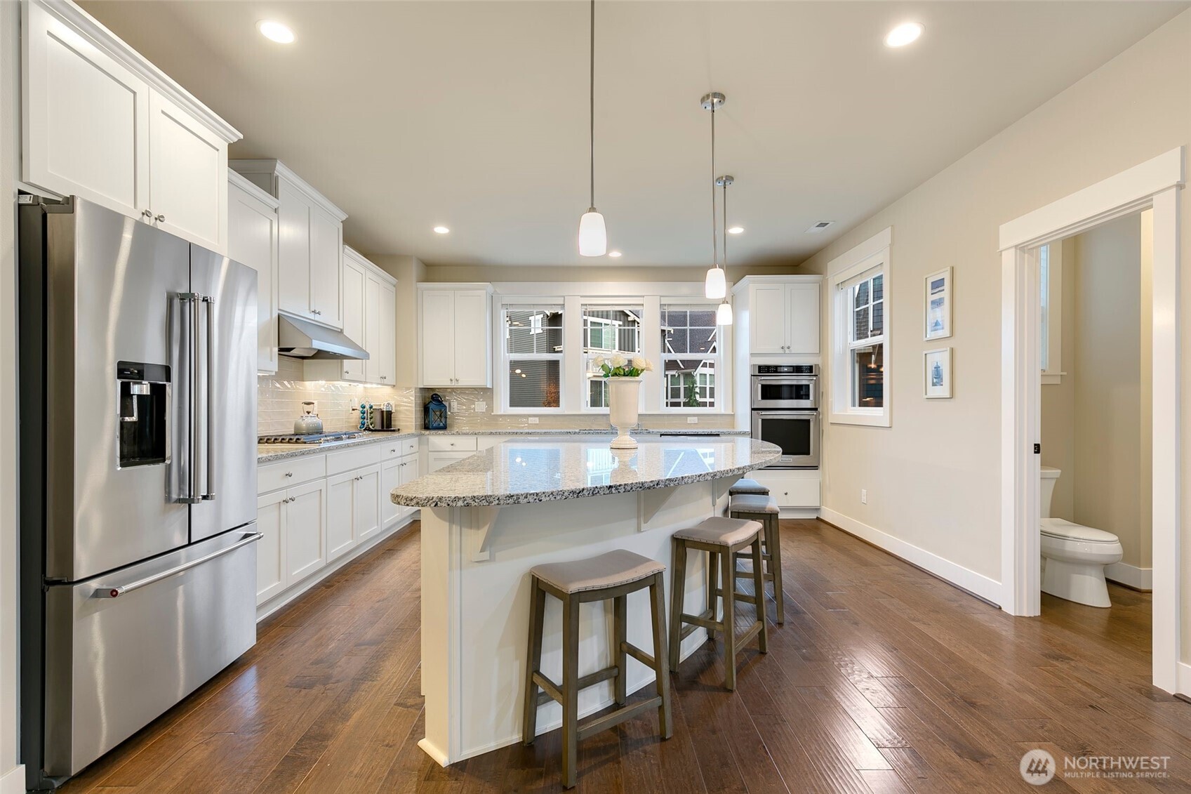 4612 186th Place Southeast, Unit A Bothell, WA 98012 - Photo 3 of 39 a kitchen with stainless steel appliances granite countertop a refrigerator a oven a sink a stove a dining table and chairs with wooden floor