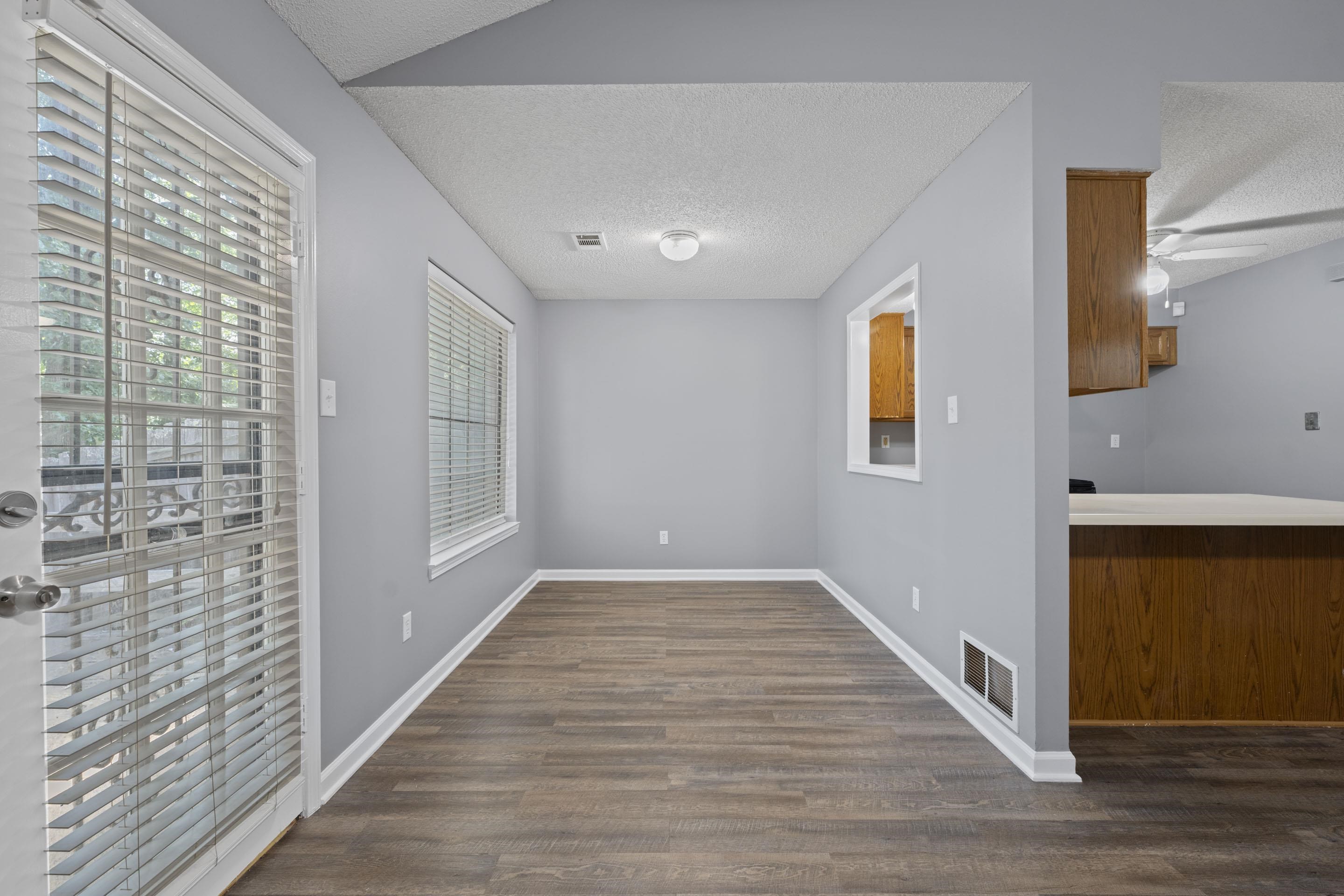 2252 Mangum Road Memphis, TN 38134 - Photo 12 of 23 Wood-finish flooring, white trim, and a pass-through window to the kitchen