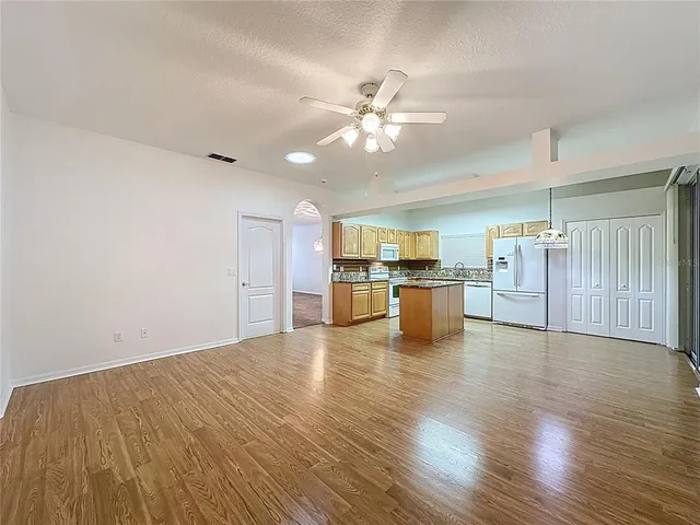 an empty room with closet and a chandelier fan
