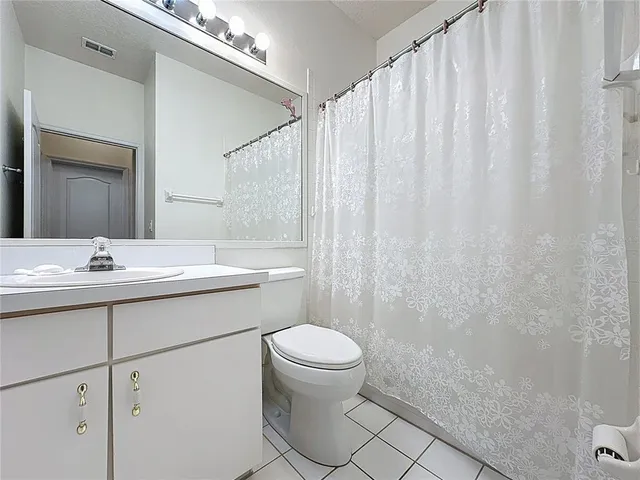 front view of house with a yard and palm trees