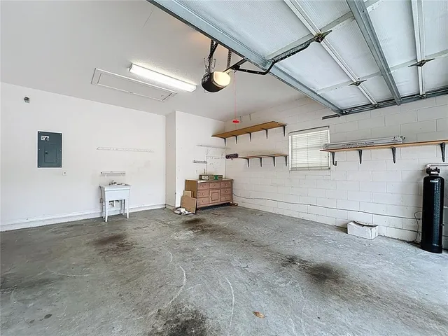 a living room with stainless steel appliances furniture a rug and a view of kitchen