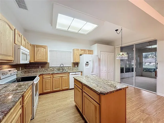 a large kitchen with cabinets wooden floor and stainless steel appliances