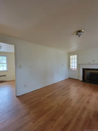 an empty room with windows and fireplace
