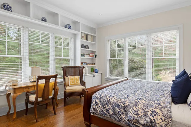 a bedroom with a bed and large windows