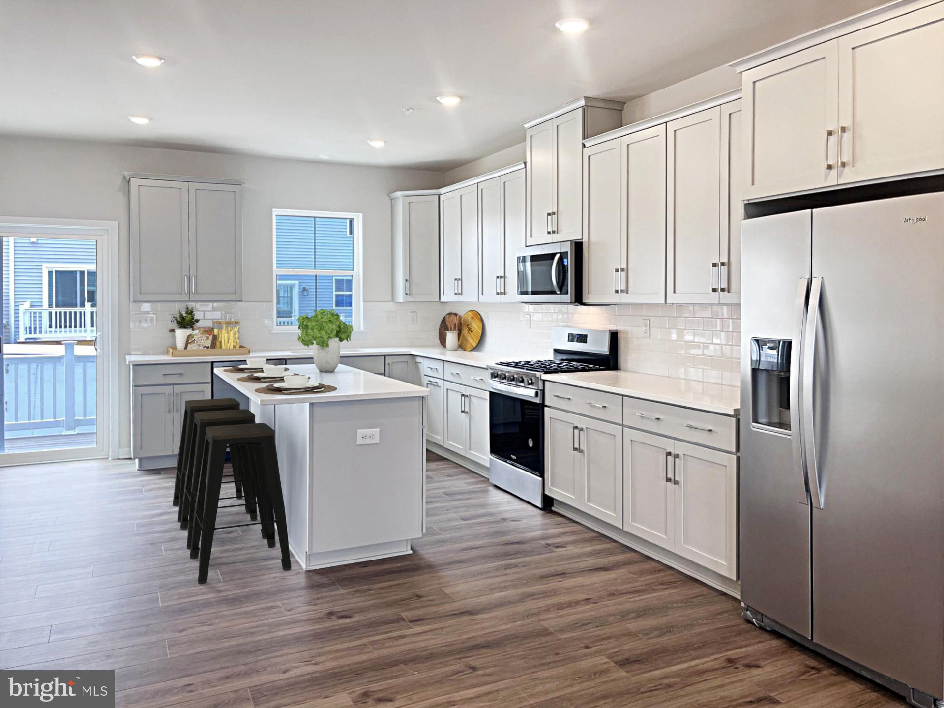 206 Bronze Street Phoenixville, PA 19460 - Photo 8 of 31 a kitchen with a refrigerator stove a sink and white cabinets with wooden floor