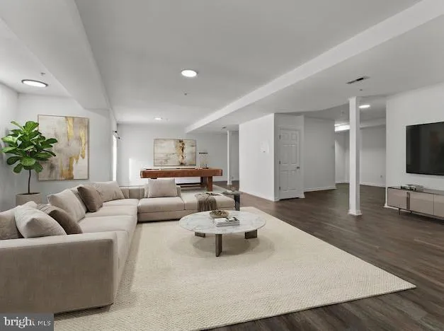 a view of an empty room with wooden floor and window