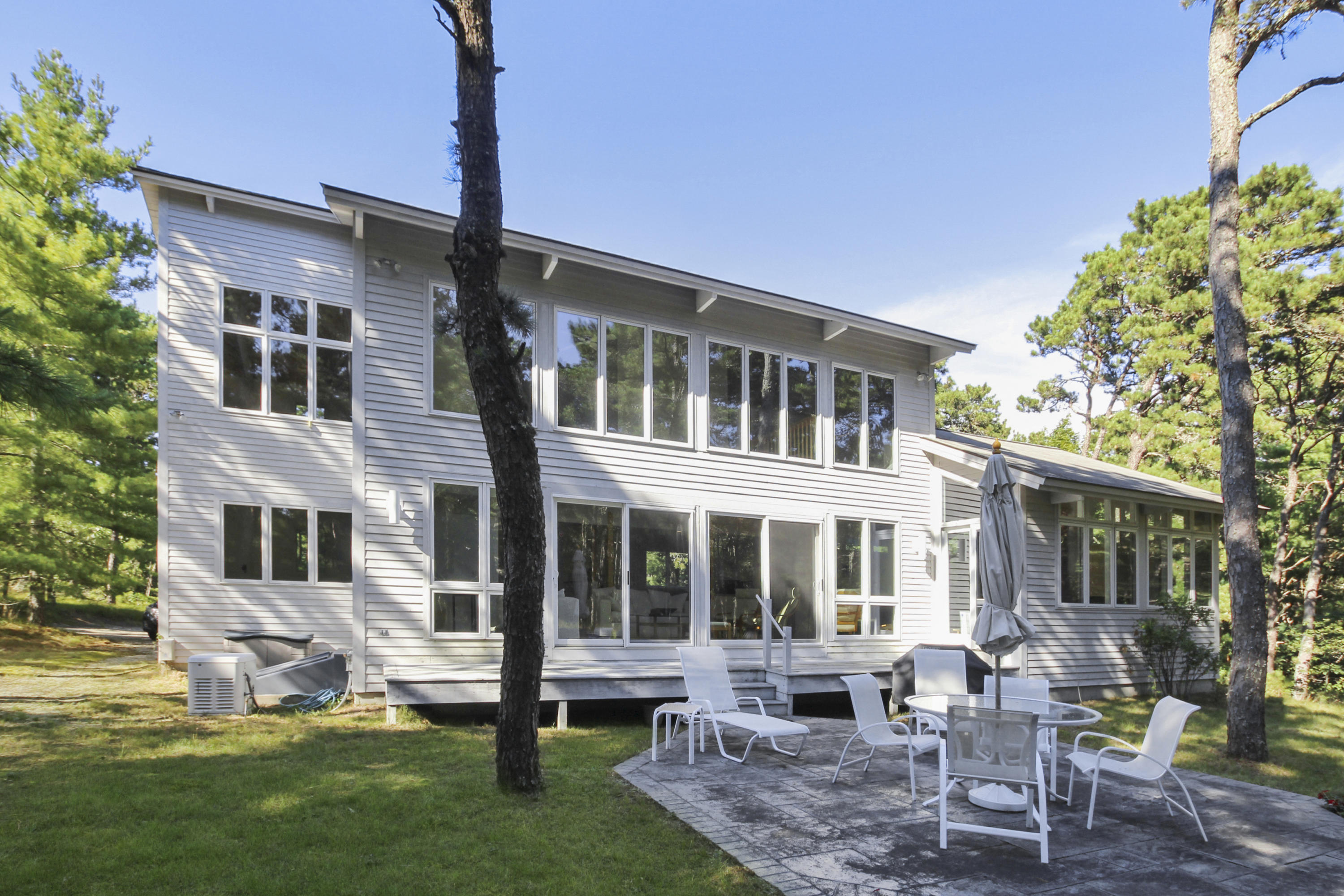 164 Long Pond Road Wellfleet, MA 02667 - Photo 2 of 33 a front view of a house with a yard table and chairs