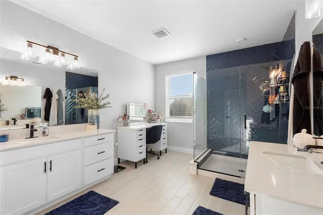 a bathroom with a double vanity sink a mirror and a shower