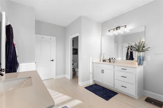 a spacious bathroom with a double vanity sink a mirror and a bathtub