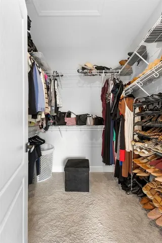 a view of walk in closet with clothes and shoes