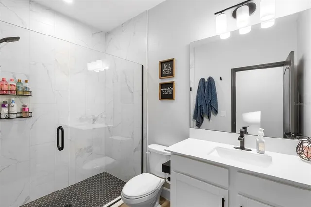 a bathroom with a sink a toilet and shower