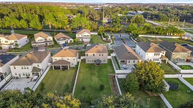 an aerial view of residential houses with outdoor space and swimming pool