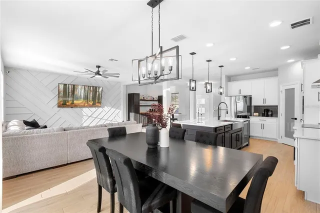 a view of a dining room and livingroom with furniture wooden floor a chandelier