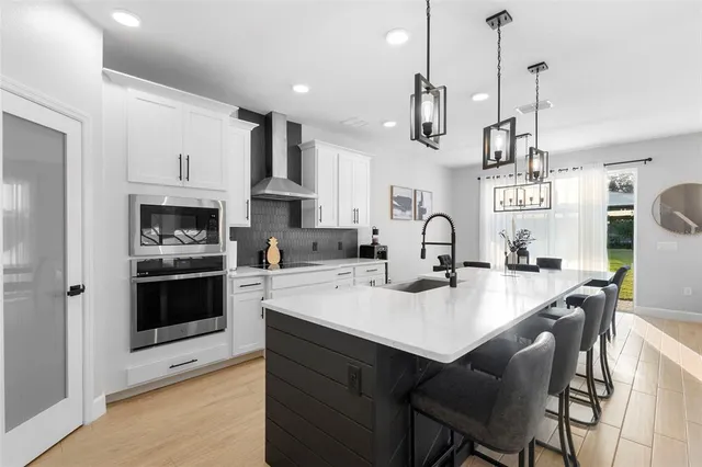 a kitchen with stainless steel appliances a stove a sink a refrigerator and cabinets