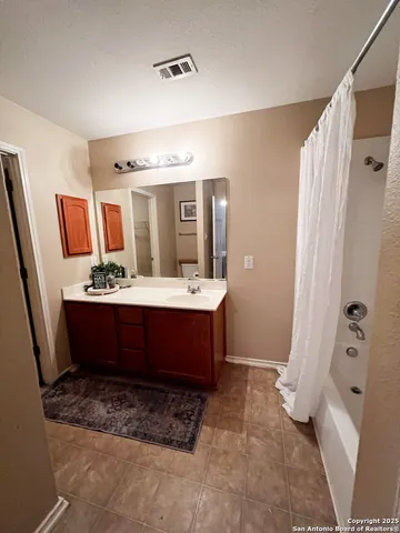 a bathroom with a double vanity sink mirror and shower