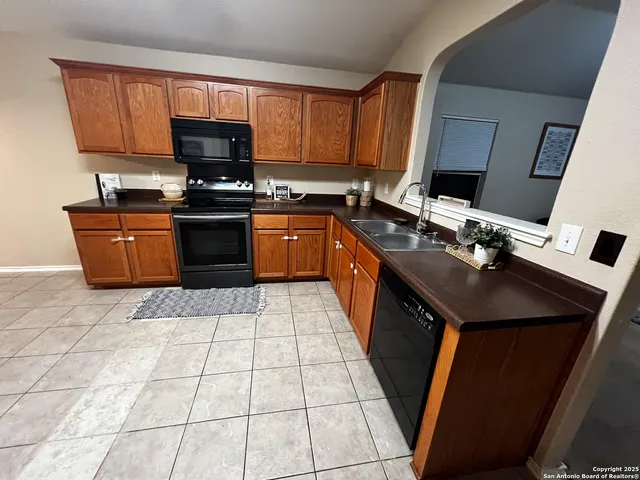 a kitchen with a sink a stove top oven a counter space and cabinets