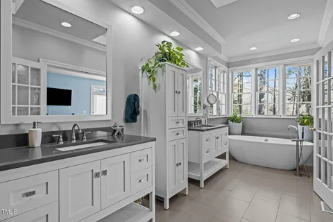 a spacious en suite bathroom with double sink and a large mirror