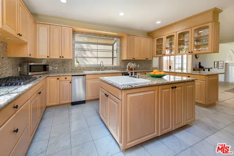 a kitchen with stainless steel appliances granite countertop a stove sink and cabinets