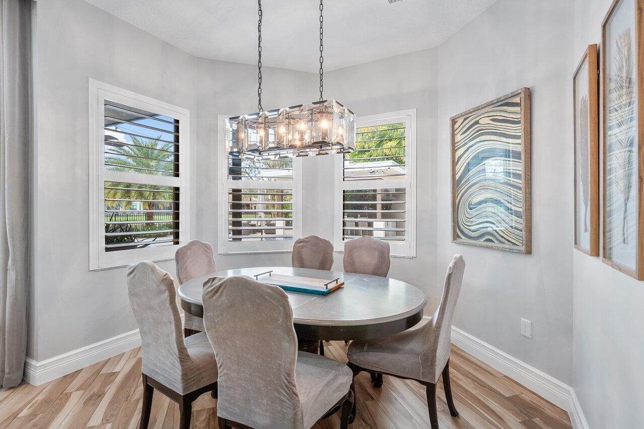 16857 Pierre Circle Delray Beach, FL 33446 - Photo 13 of 57 a dining room with furniture a chandelier and wooden floor