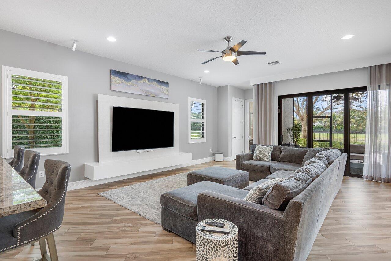 16857 Pierre Circle Delray Beach, FL 33446 - Photo 14 of 57 a living room with furniture floor to ceiling window hardwood floor and a flat screen tv