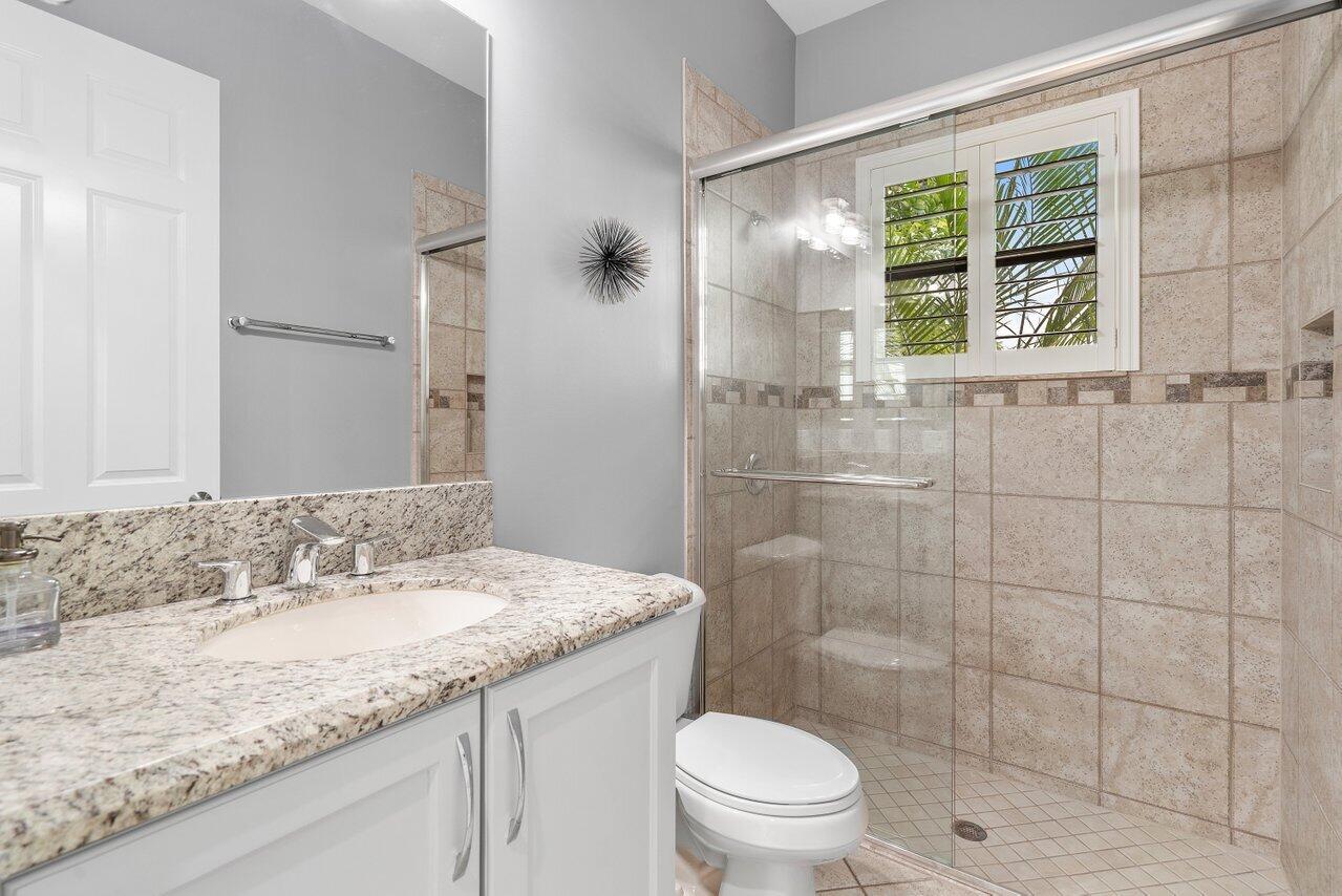 16857 Pierre Circle Delray Beach, FL 33446 - Photo 18 of 57 a bathroom with a granite countertop sink a toilet and shower