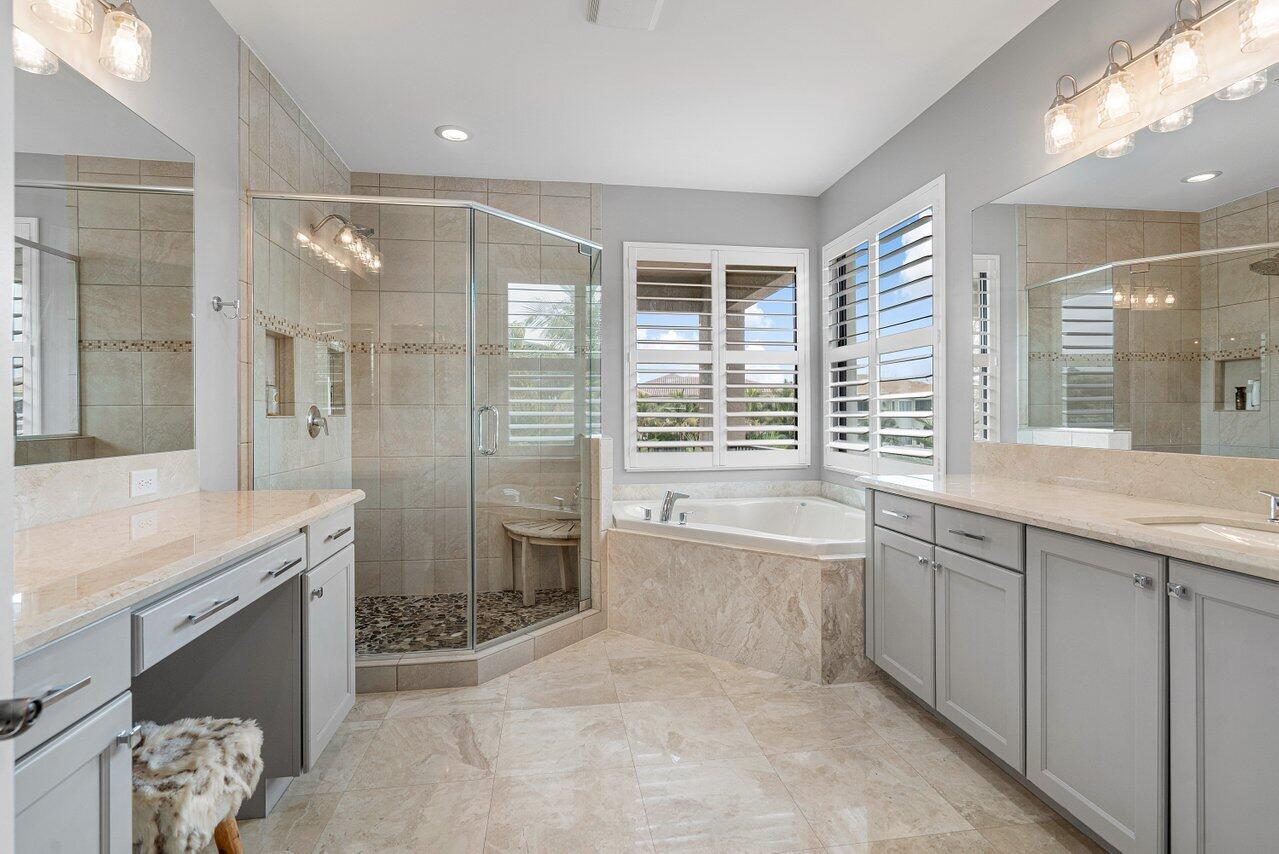16857 Pierre Circle Delray Beach, FL 33446 - Photo 27 of 57 a spacious bathroom with a granite countertop tub sink a shower and a mirror