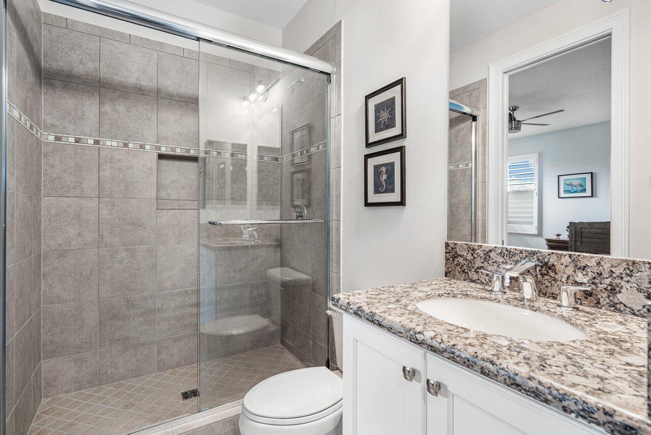 16857 Pierre Circle Delray Beach, FL 33446 - Photo 31 of 57 a bathroom with a granite countertop sink a toilet and shower