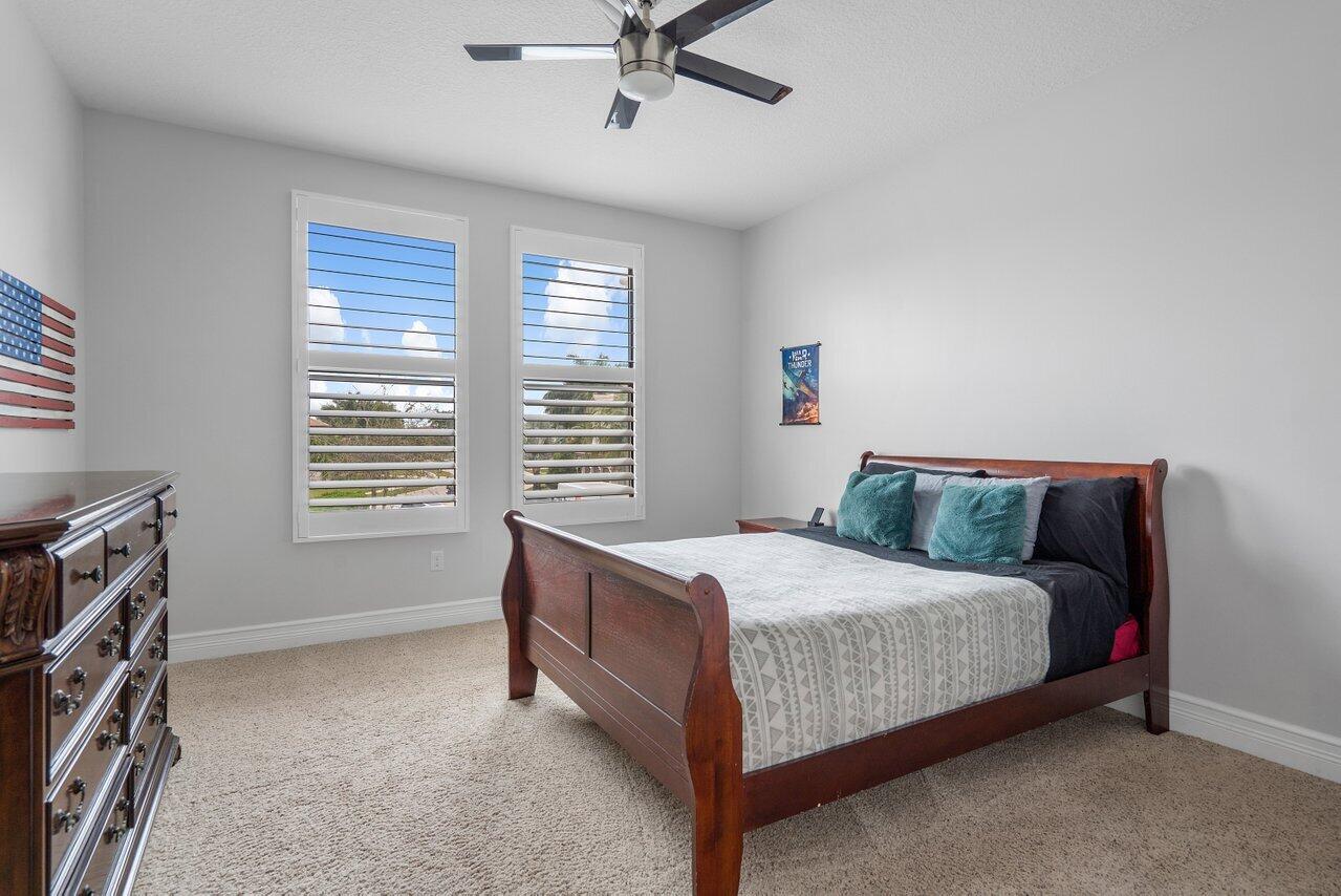 16857 Pierre Circle Delray Beach, FL 33446 - Photo 32 of 57 a bedroom with a bed and a ceiling fan