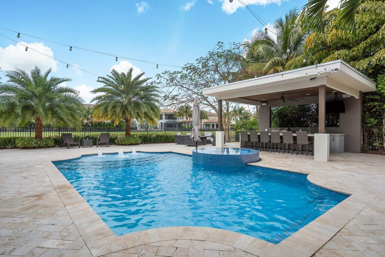 16857 Pierre Circle Delray Beach, FL 33446 - Photo 44 of 57 a view of a swimming pool with a patio and a garden