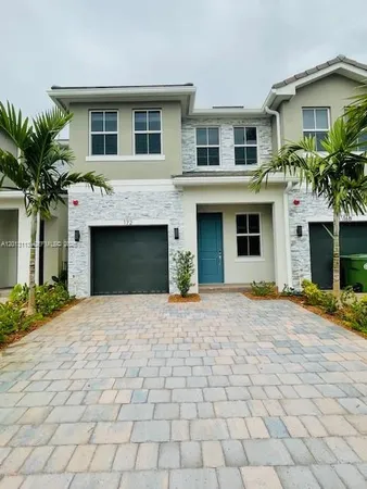 a front view of a house with a yard and a garage