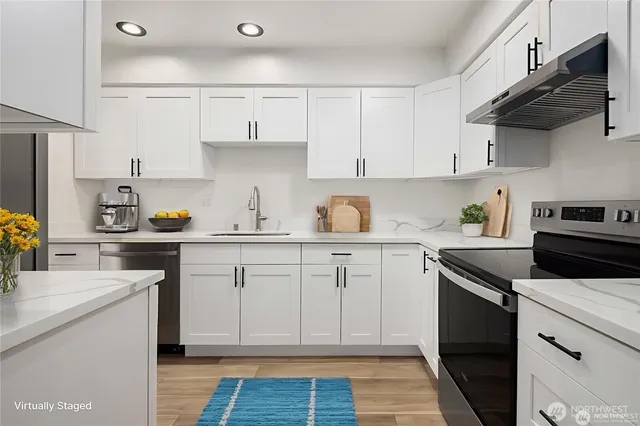 a kitchen with cabinets appliances a sink and a counter space