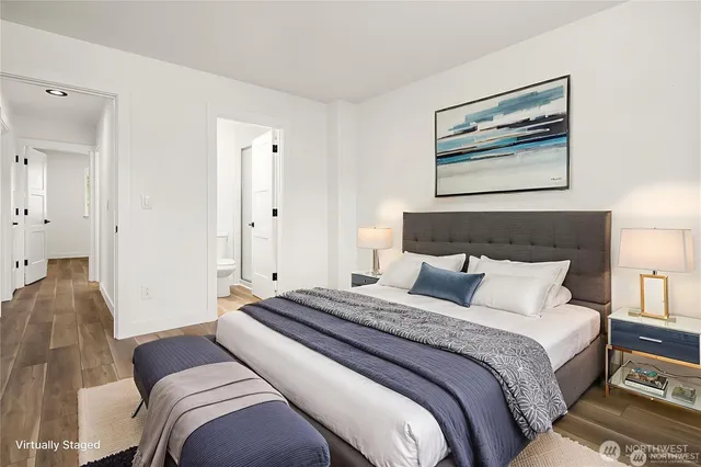 a bedroom with a large bed and a painting on the wall