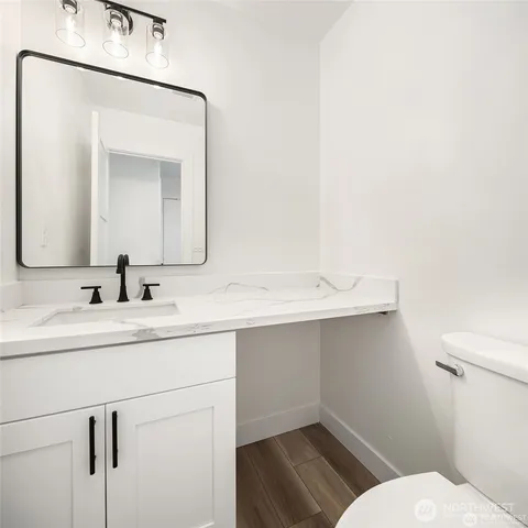 a bathroom with a toilet sink and mirror