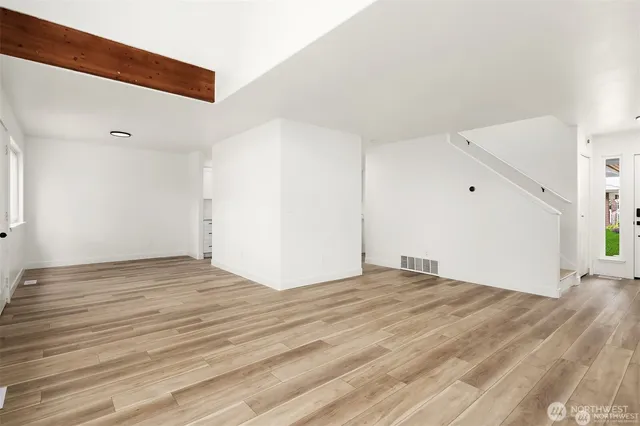 a view of an empty room with wooden floor