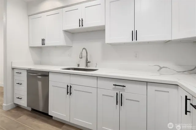 a kitchen with white cabinets and a sink