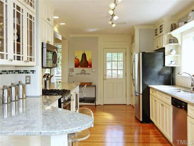 512 Chesterfield Road Raleigh, NC 27608 - Photo 8 of 25 a kitchen with stainless steel appliances granite countertop a refrigerator a stove and a sink with wooden floor