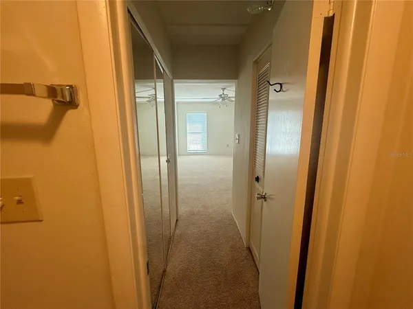 an empty room with a ceiling fan and a window