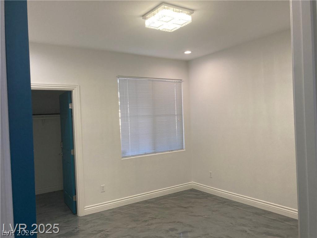 9050 West Warm Springs Road, Unit 1027 Las Vegas, NV 89148 - Photo 20 of 44 Well-lit room with modern light fixtures and durable flooring, offering a versatile living space.