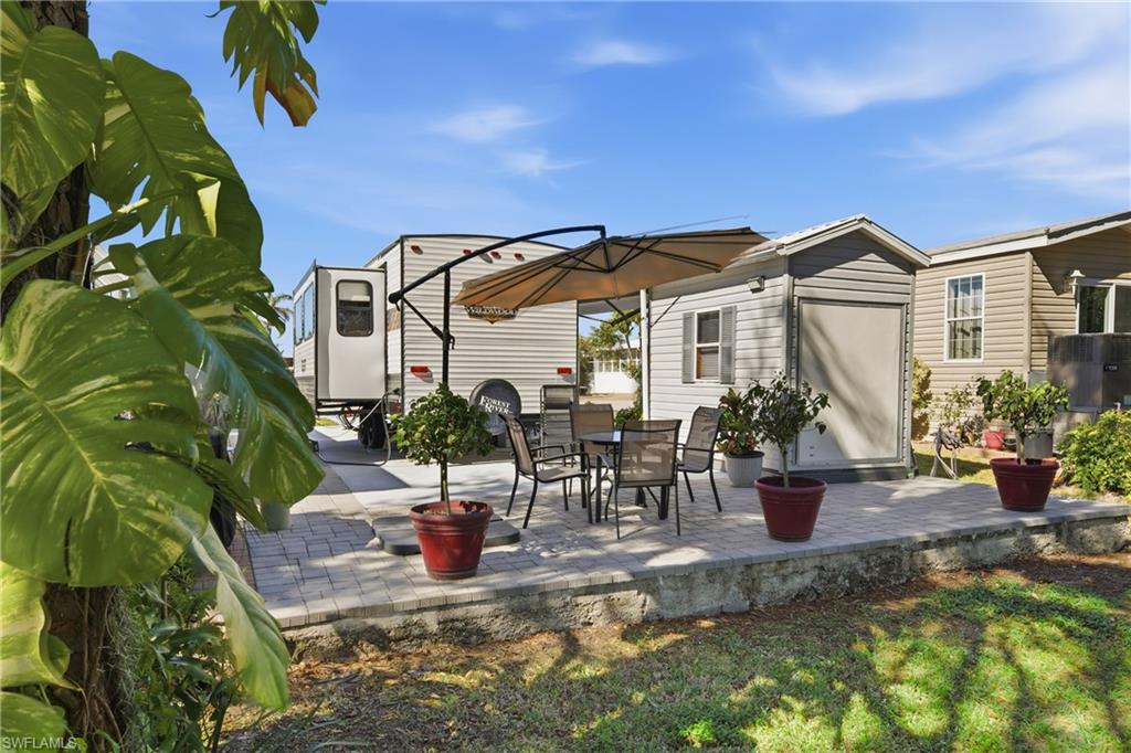 26 Bass Lane Naples, FL 34114 - Photo 4 of 26 View of patio featuring outdoor dining space and an outdoor structure