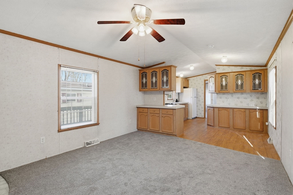15 Quaboag Valley, Unit 15 Sudbury, MA 01776 - Photo 8 of 35 a living room with stainless steel appliances kitchen island furniture and a ceiling fan