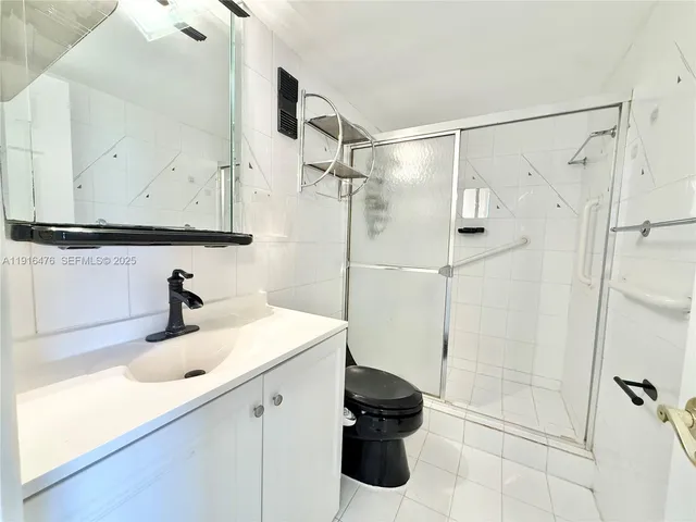 a bedroom with a bed and a lamp on dresser