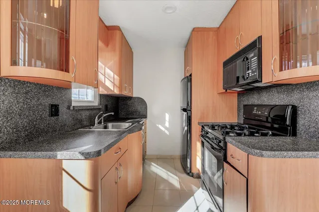a kitchen with stainless steel appliances granite countertop a sink stove and microwave