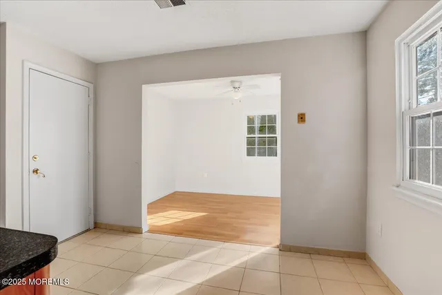 a view of an empty room with window and an empty room