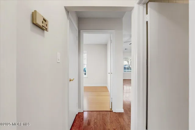 a view of a hallway with wooden floor and closet