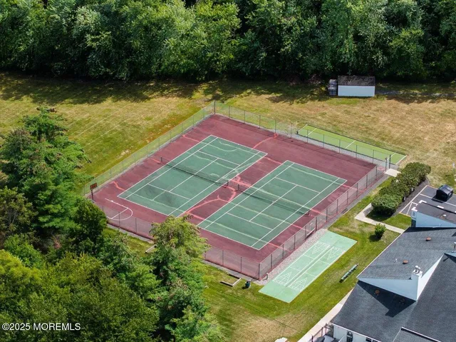 an aerial view of a tennis ground with a swimming pool